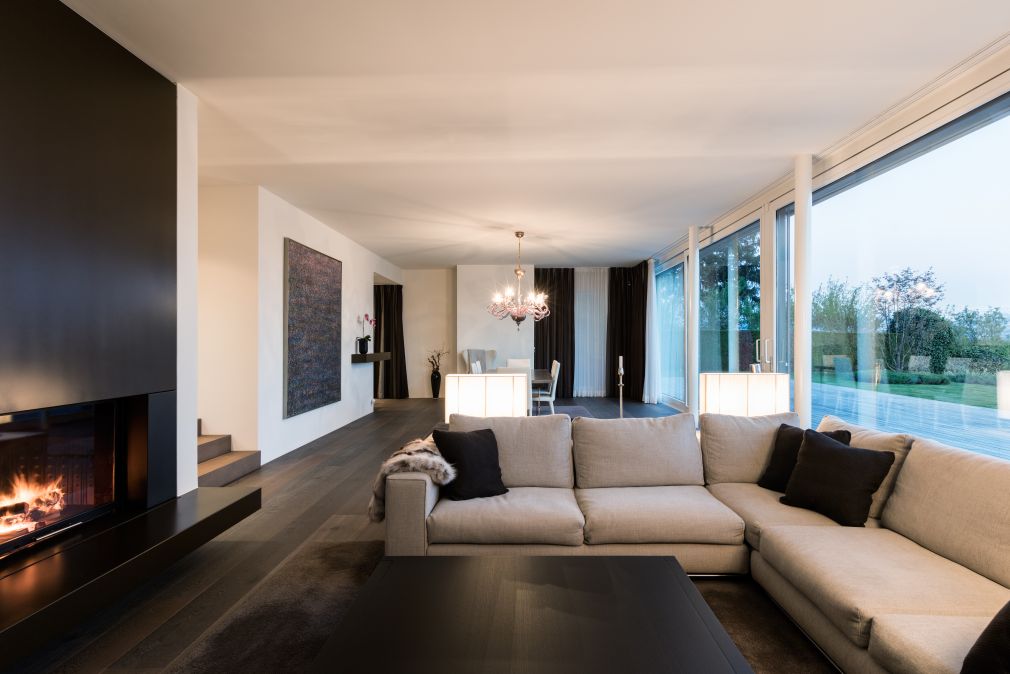 Wohnraum mit Cheminée und dunklem Parkett